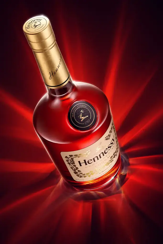 A highly refined 3d cgi visualization of a red cognac bottle surrounded by surreal caustic effects. High quality advertising rendering in CGI