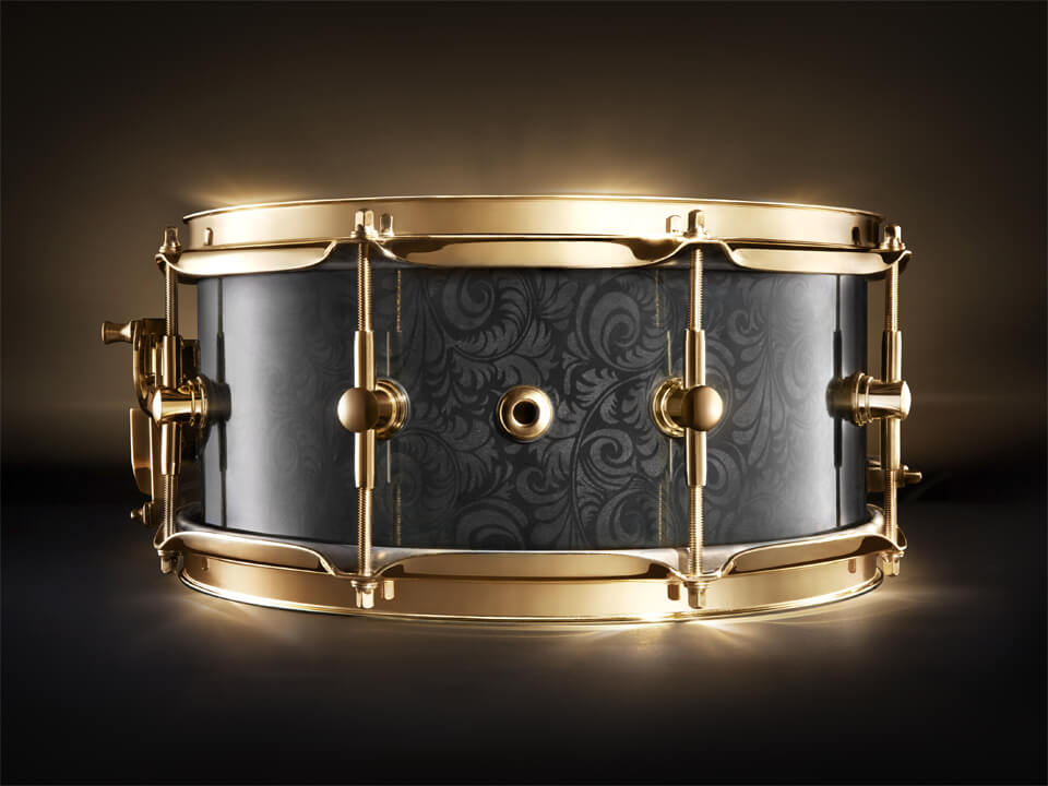 High-End product photography and retouching of a black snare drum with golden hardware. Super precious looking with a golden glow.